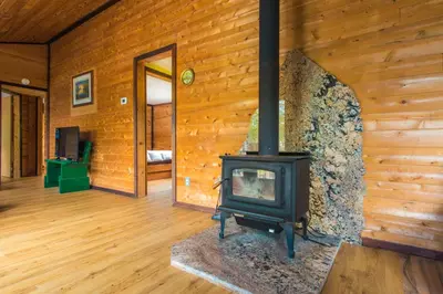 a woodburning stove in a room in a log cabin at Beautiful 3 Bdrm + Bunkie Waterfront Cottage Near Gull Lake in Minden