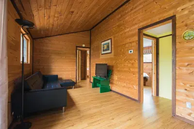 a living room with a couch and a mirror at Beautiful 3 Bdrm + Bunkie Waterfront Cottage Near Gull Lake in Minden