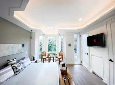 a bedroom with a bed and a table with chairs at Elegant Downtown Home in Toronto