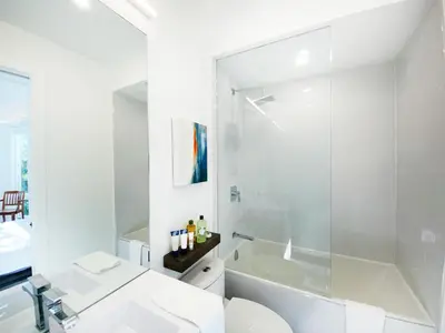 a white bathroom with a sink and a shower at Elegant Downtown Home in Toronto