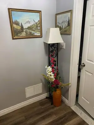 a lamp and a vase with flowers in a hallway at Luxury Suites at Military Trail in Toronto