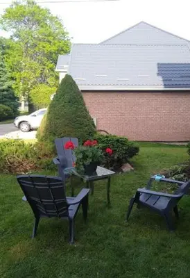 two chairs and a table with flowers in a yard at Luxury Suites at Military Trail in Toronto