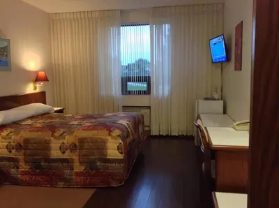 a hotel room with a bed and a desk and a television at Shakespeare Inn in Shakespeare