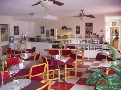 a restaurant with tables and chairs and a kitchen at Shakespeare Inn in Shakespeare
