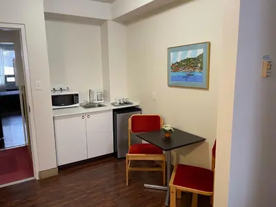 a small room with a small table and a kitchen at Shakespeare Inn in Shakespeare