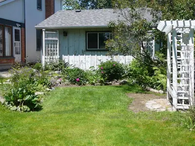 a yard with a white fence in front of a house at Gables Bed & Breakfast in Stayner