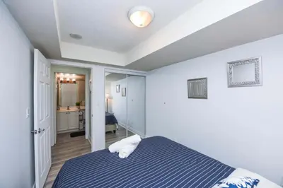 a bedroom with a bed and a hallway with a bathroom at PlanURstay - Luxury 1BR Condo with City View in Mississauga