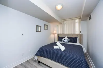 a bedroom with a blue bed with pillows on it at PlanURstay - Luxury 1BR Condo with City View in Mississauga