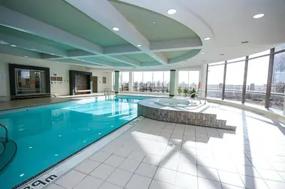 a large swimming pool in a building with windows at PlanURstay - Luxury 1BR Condo with City View in Mississauga