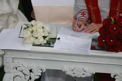 a man signing a document on a table with roses at Plantation House Bed & Breakfast in Port Hope
