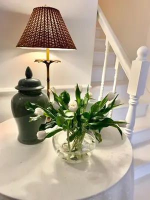 a lamp and a vase with flowers on a table at Plantation House Bed & Breakfast in Port Hope