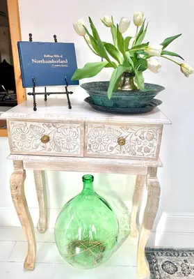 a table with a glass vase and a vase of flowers at Plantation House Bed & Breakfast in Port Hope