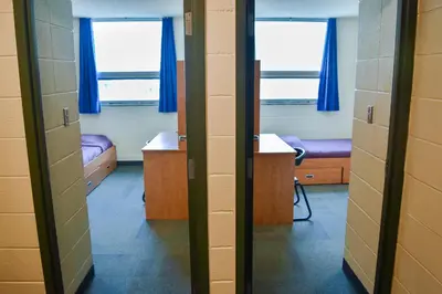 a room with two beds and two windows at Toronto Metropolitan University- Pitman Hall Residence in Toronto