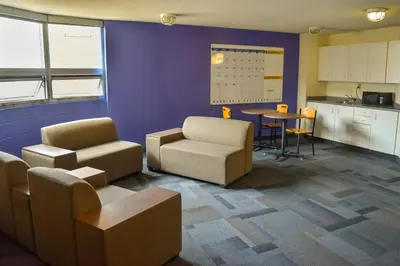 a room with chairs and a table and a kitchen at Toronto Metropolitan University- Pitman Hall Residence in Toronto