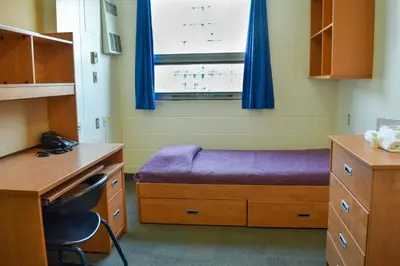 a room with a bed and a desk and a window at Toronto Metropolitan University- Pitman Hall Residence in Toronto