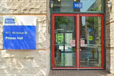 a red phone booth in front of a building at Toronto Metropolitan University- Pitman Hall Residence in Toronto