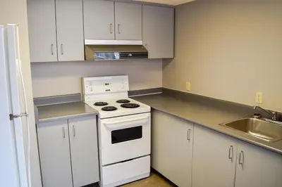a kitchen with white cabinets and a stove and a sink at Toronto Metropolitan University-International Living Learning Residence in Toronto