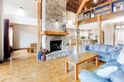 a living room with a stone fireplace and blue couches at Lucille 109 in Blue Mountains