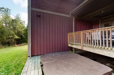 a porch of a red house with a wooden deck at Lucille 109 in Blue Mountains