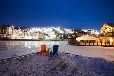 two chairs and a table in the snow at night at Cachet Crossing in Blue Mountains