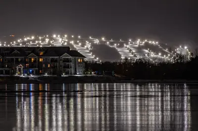 a building next to a lake at night at Condo 206 at North Creek Resort in Blue Mountains