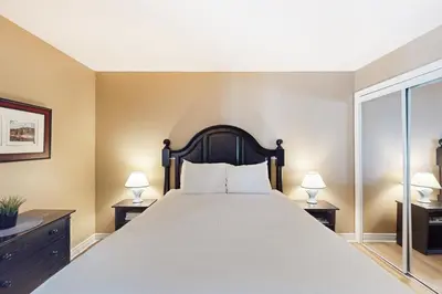 a bedroom with a large bed with two lamps at Condo 904 at North Creek Resort in Blue Mountains