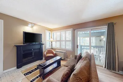 a living room with a couch and a flat screen tv at Condo 904 at North Creek Resort in Blue Mountains