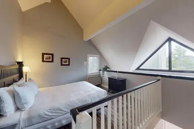 a attic bedroom with a bed and a window at Condo 310 at North Creek Resort in Blue Mountains