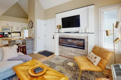 a living room with a fireplace with a tv above it at Condo 413 at North Creek Resort by Vacasa in Blue Mountains