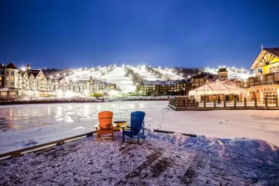 two chairs sitting in the snow in front of a town at Condo 413 at North Creek Resort by Vacasa in Blue Mountains