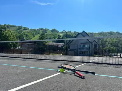 a tennis racket and ball on a tennis court at Condo 413 at North Creek Resort by Vacasa in Blue Mountains