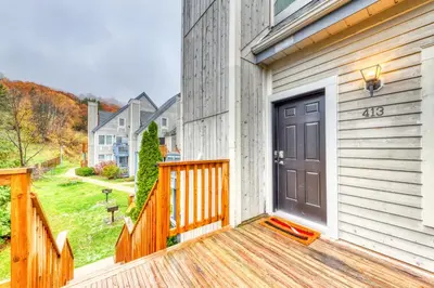 a house with a wooden porch with a door at Condo 413 at North Creek Resort by Vacasa in Blue Mountains