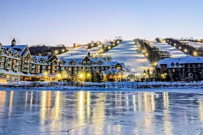 a resort covered in snow next to a body of water at Condo 704 at North Creek Resort in Blue Mountains
