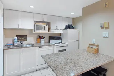 a kitchen with white cabinets and a counter top at Condo 704 at North Creek Resort in Blue Mountains