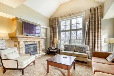 a living room with a fireplace and a tv at Rivergrass 226 in Blue Mountains