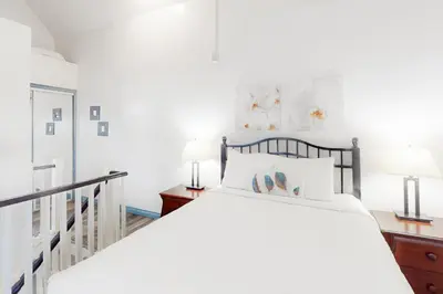 a white bedroom with a bed and two lamps at Condo 416 at North Creek Resort in Blue Mountains