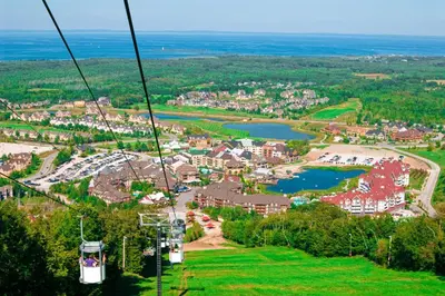 a gondola ride over a town and a lake at Condo 710 at North Creek Resort in Blue Mountains