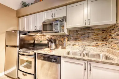 a kitchen with white cabinets and a stainless steel refrigerator at Condo 214 at North Creek Resort by Vacasa II in Blue Mountains
