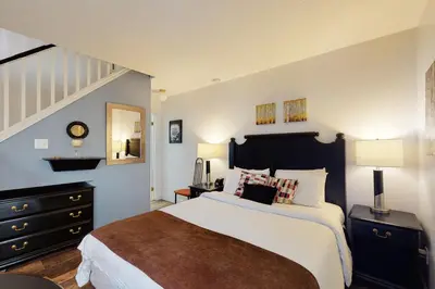 a bedroom with a large bed and a staircase at Condo 212 at North Creek Resort by Vacasa in Blue Mountains