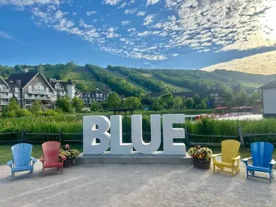 a large blue sign with colorful chairs in front at Wintergreen 223 in Blue Mountains