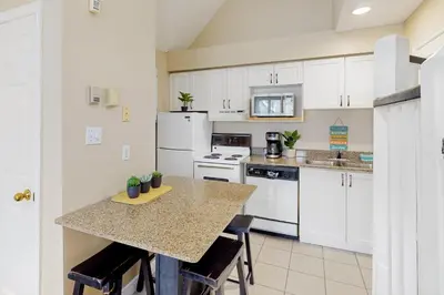 a kitchen with white cabinets and a table with chairs at Condo 816 at North Creek Resort in Blue Mountains
