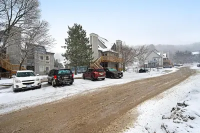 a snowy street with cars parked on a snow covered road at Condo 614 at North Creek Resort in Blue Mountains