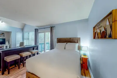 a bedroom with a large white bed and a desk at Condo 110 at North Creek Resort in Blue Mountains