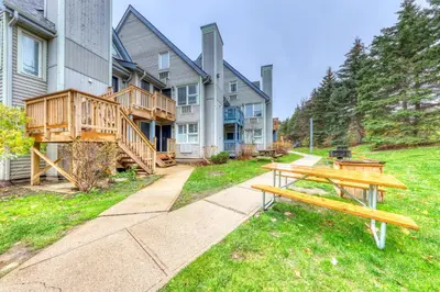 a park bench in front of a house at Condo 110 at North Creek Resort in Blue Mountains