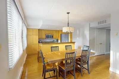 a kitchen and dining room with a wooden table and chairs at Wintergreen 202 in Blue Mountains