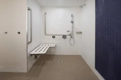 a bathroom with a bench and a shower at Fairfield by Marriott Niagara Falls, Canada in Niagara Falls