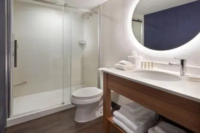 a bathroom with a toilet and a sink and a mirror at Fairfield by Marriott Niagara Falls, Canada in Niagara Falls