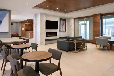 a lobby with tables and chairs and a fireplace at Fairfield by Marriott Niagara Falls, Canada in Niagara Falls