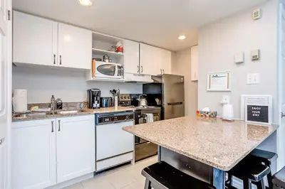 a kitchen with white cabinets and a granite counter top at Mountainside Resort Condo at Blue in Blue Mountains