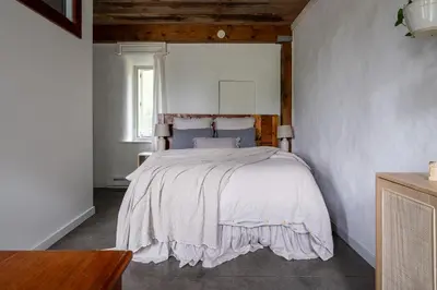 a bedroom with a large bed with a wooden headboard at Owl's Nest Suites in Carrying Place